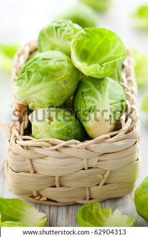 Wet brussels sprouts in basket on the white wooden table