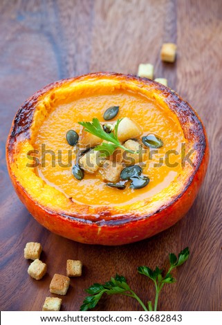 Cream of pumpkin soup with pumpkin seeds and and garlic croutons  in hollowed-out pumpkin