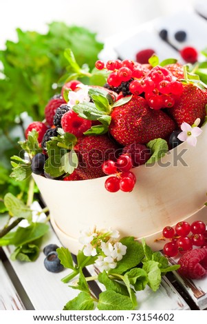 fresh berries with leaves in a wooden basket
