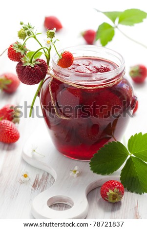 strawberry jam in a jar and fresh berries on the wooden table