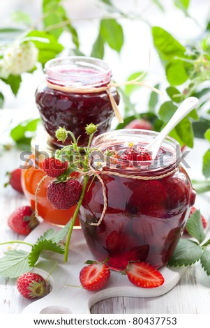 strawberry,apricot, raspberry jam in a jars and fresh berries