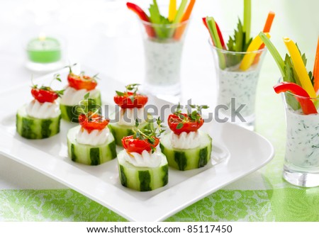 Holiday vegetable appetizers.Cucumbers with soft cheese and sun dried tomatoes and vegetable sticks with dip