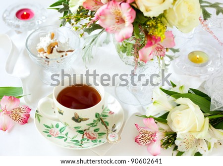 beautiful flowers in vase , cup of tea and biscuits