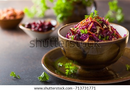 Red cabbage, carrot, apple salad with nuts and cranberry. Coleslaw for autumn or winter season.
