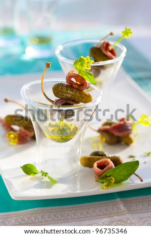 Anchovies with capers and cornichons on cocktail sticks