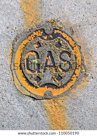 vintage yellow painted gas manhole on concrete surface, energy details