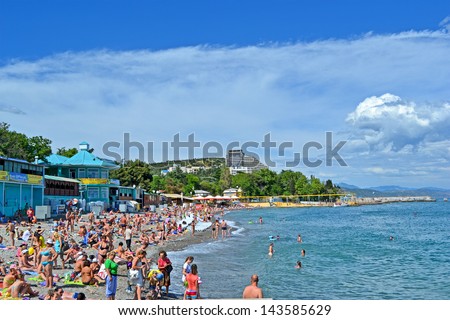 ALUSHTA, UKRAINE - JUN 01: People on the public pebble beach near Black Sea in Alushta, Ukraine on June 01, 2013. Alushta is famous Crimean resort. More 6,134 mln. tourists visited Crimea in 2012.