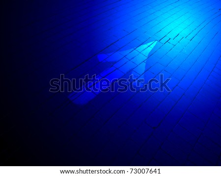 abstract blue lighting, painted white direction sign over brick road, transportation concept