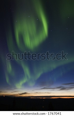 Aurora borealis swirls in the twilight sky