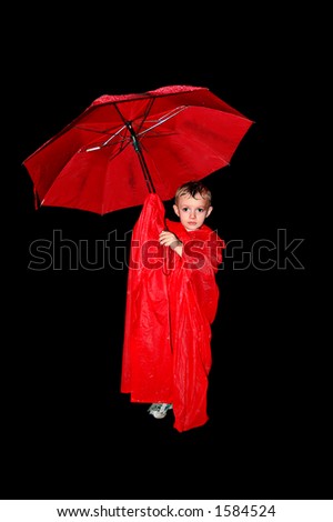 Tired sad boy standing in the rain wearing a poncho with an umbrella with black background
