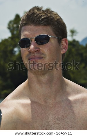 Young Man with sunglasses driving boat