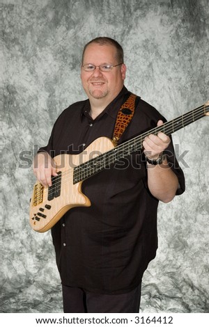 middle-age male musician posing with guitar against portrait backdrop