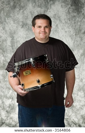overweight young man posing in front of portrait backdrop