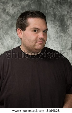overweight young man posing in front of portrait backdrop