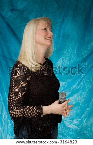 beautiful middle aged woman posing in front of portrait backdrop