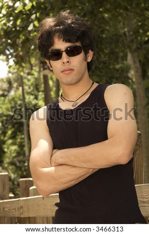 handsome young male model outside on a boardwalk leaning on the railing