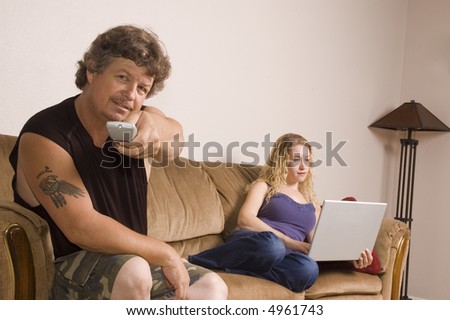 Man and woman relax on the couch with laptop