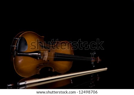 low key image of antique violin and bow with reflection