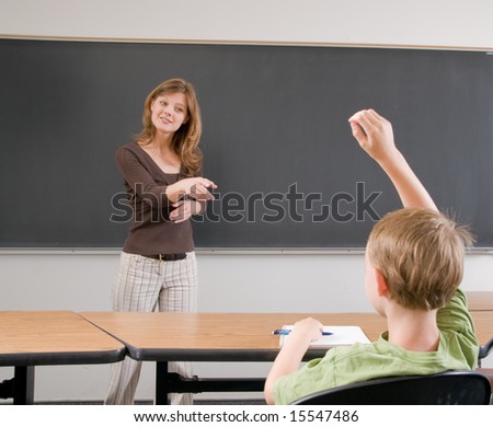 stock photo : teacher points to child with raised hand