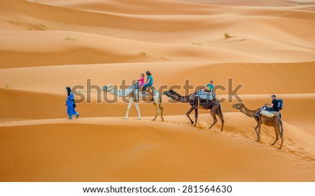 ERG CHEBBY, MOROCCO - April, 12, 2013: Tourists riding camels in Erg Chebbi, Morocco