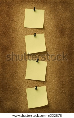 four yellow notes pinned to grunge cork background