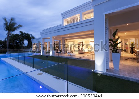 Beautiful white villa with warm illumination and a fancy swimming pool