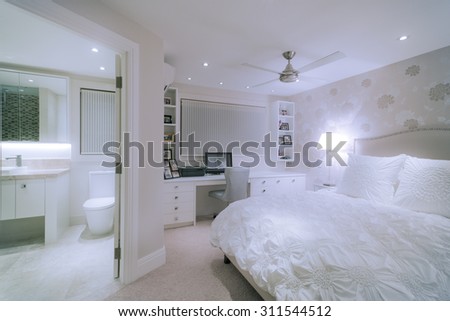 Luxurious white bedroom with an extra big bed and a private bathroom