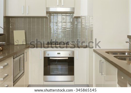 Small modern kitchen with built in stove and microwave