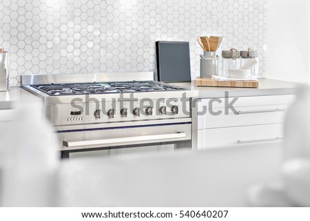 Modern gas stove top view with kitchen utensils beside bee shape wall tile, front is blurred and focus the back, very clean area also perfect lightning.