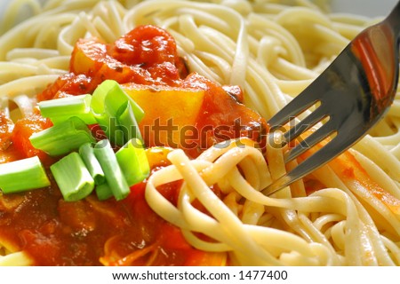Plate of spaghetti with tomato sauce and a fork.