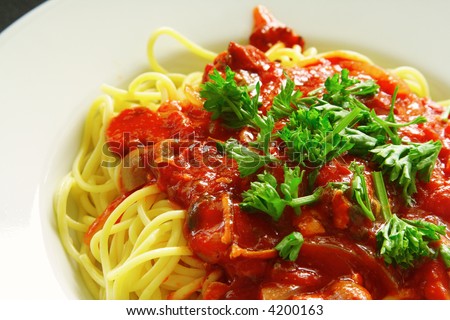 Freshly cooked plate of spaghetti with seafood sauce sprinkled with fresh green herbs.