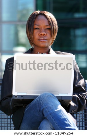 African american woman holding notebook in an office environment.