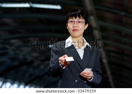 Asian woman giving her business calling card with a friendly smile