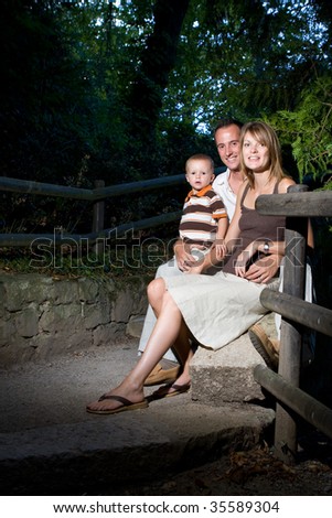 Happy perfect young family with dad, mom and son outdoors having fun