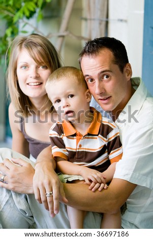 Happy perfect young family with dad, mom and son outdoors having fun
