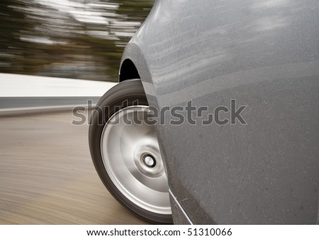Car moving very fast or speeding with wheels spinning making a left turn