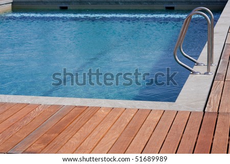 Luxury swimming pool blue water with a wooden deck