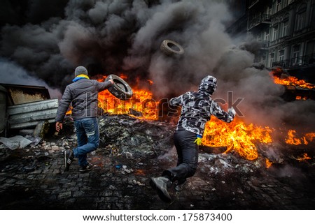 Revolutionaries throw tires in the fire to defend against attack by police. Ukraine, Kiev  on January 23, 2014.
