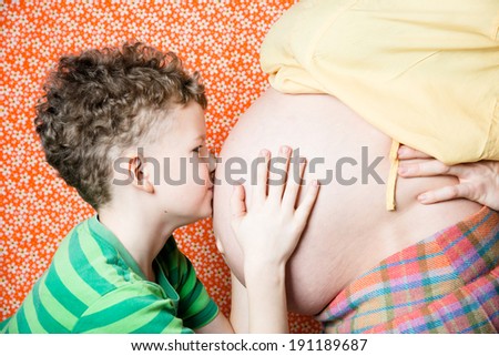 Son kissing his mother pregnant tummy