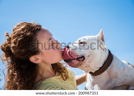Girl kissing dog breed Staffordshire Terrier