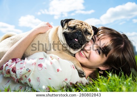 Girl hugging dog breed Mops