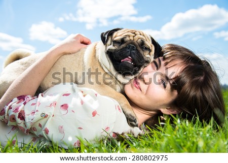 Girl hugging dog breed Mops