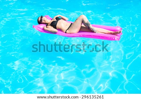 Girl swims in the pool on an inflatable mattress