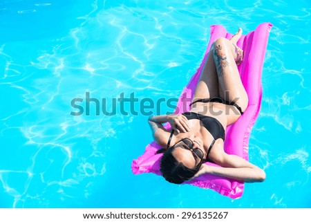 Girl swims in the pool on an inflatable mattress