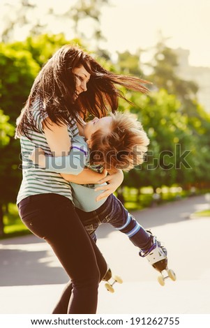 Mother and son spinning in summer park