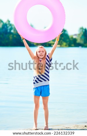 happy girl play swim ring at the beach