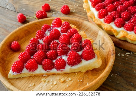 Delicious raspberry tarts on a wooden board