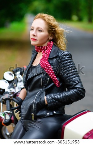 Biker girl in leather jacket on a motorcycle