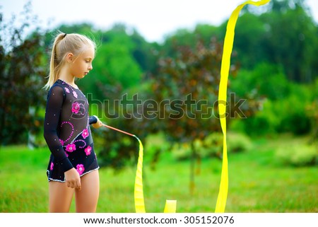 Young gymnast warms up with a gymnastic tape or feed