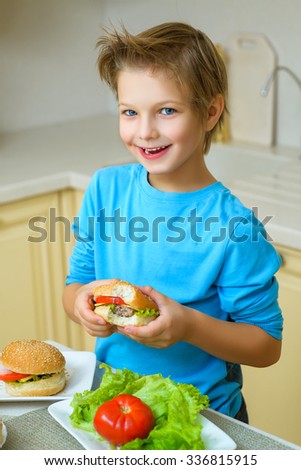 smiling happy boy holding homemade hamburgers or sandwiches